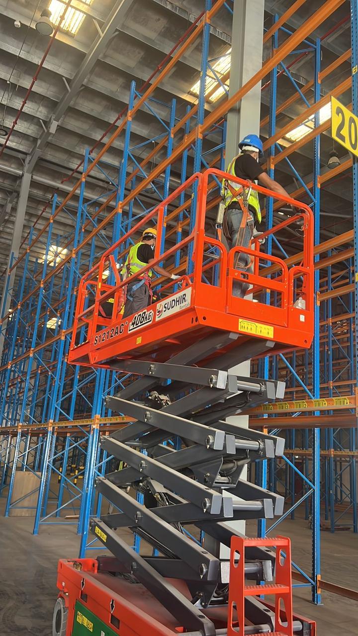 Technicians on a scissor lift installing tall pallet racking